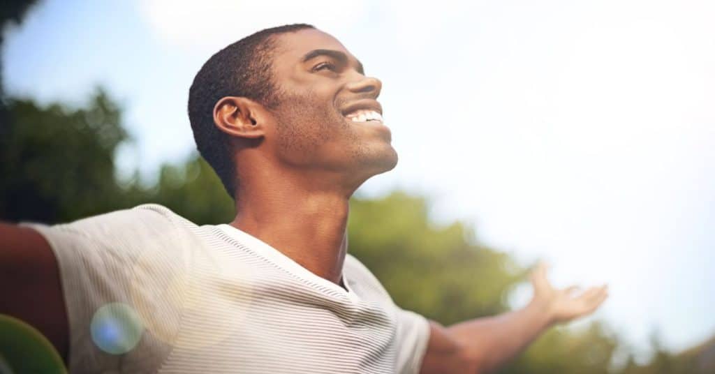 Smiling man basking in the rays of the sun